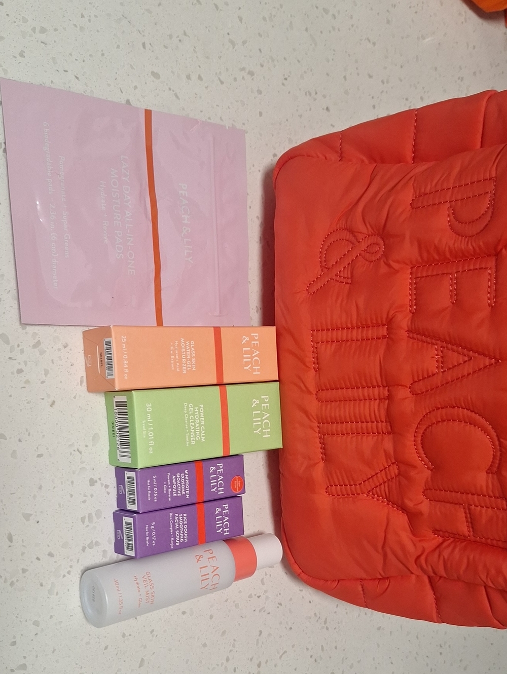 Peach And LILY Orange Quilted Cosmetic Bag with Skincare Set
